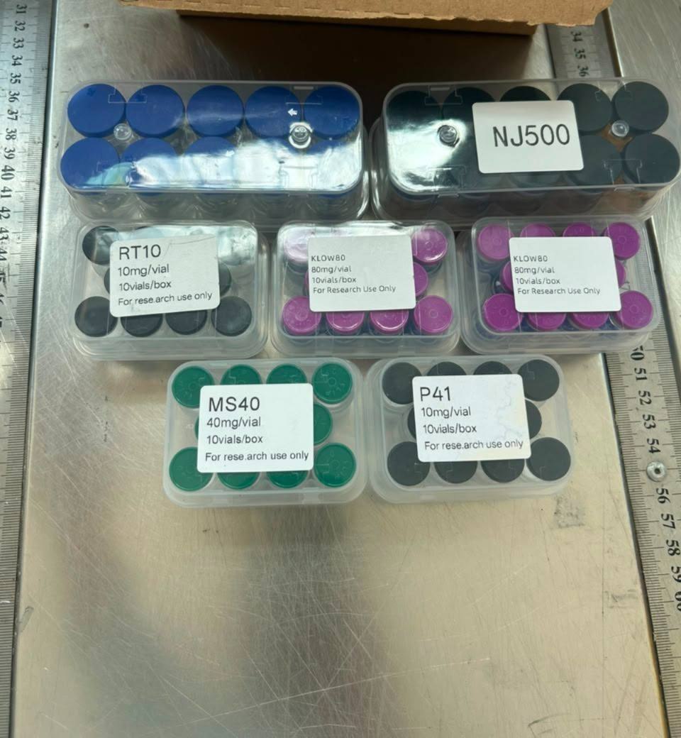 Several different labelled product trays shown together on a steel workbench